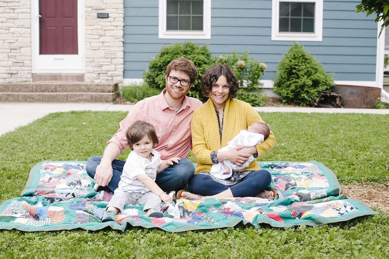 Family in front of home on blanket