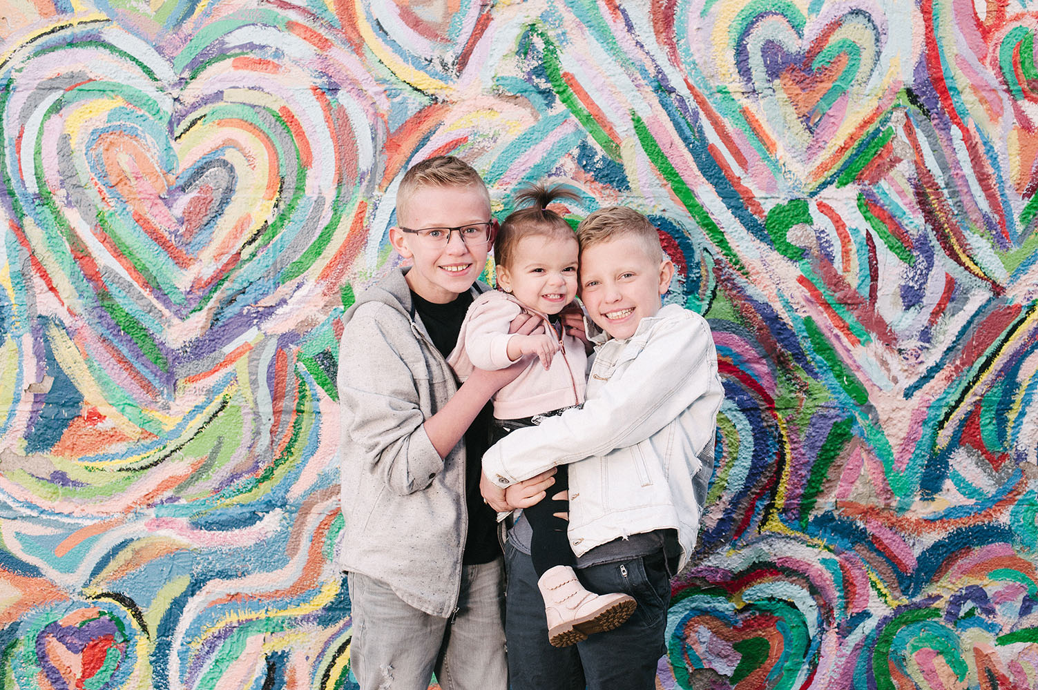 Family in front of rainbow heart mural