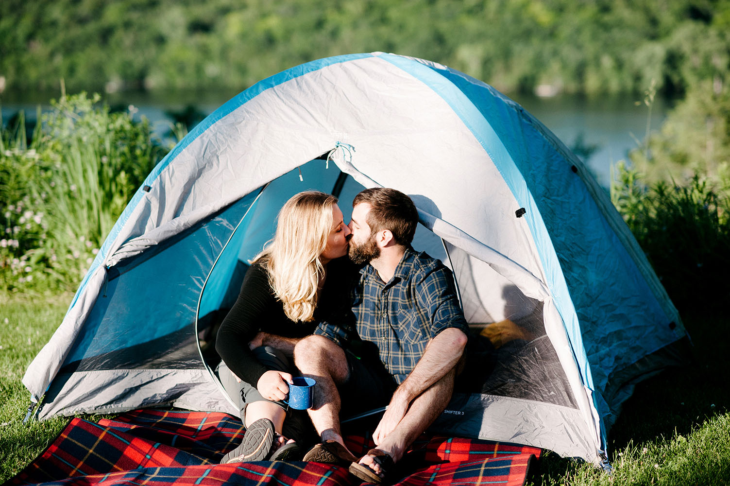 a couple kissing in front of a tent