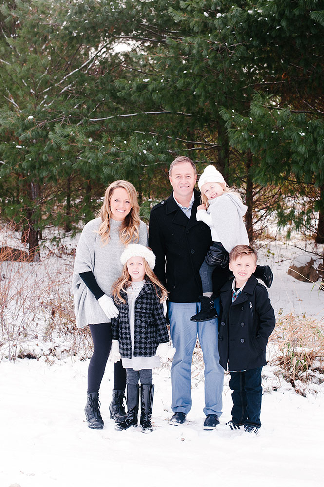 Family in front of pine trees in the winter