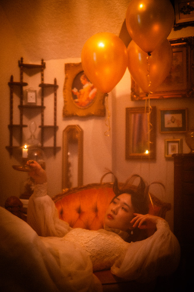 a young asian girl on a couch with balloons