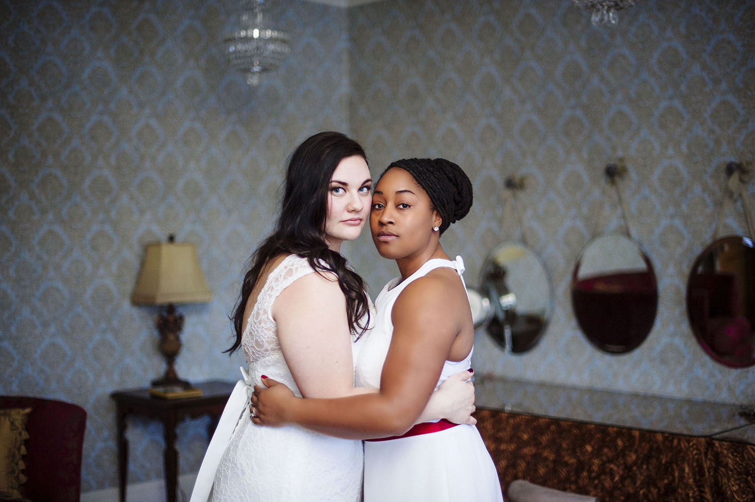 Same sex wedding, caucasian bride and African American bride embracing eachother at Semple Mansion