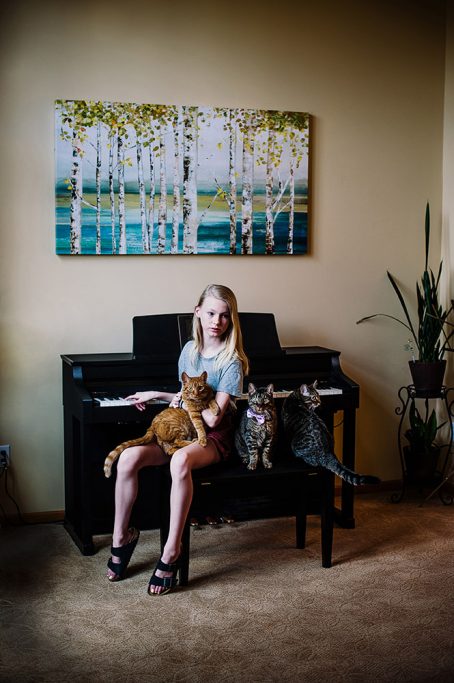 Girl playing piano with cats