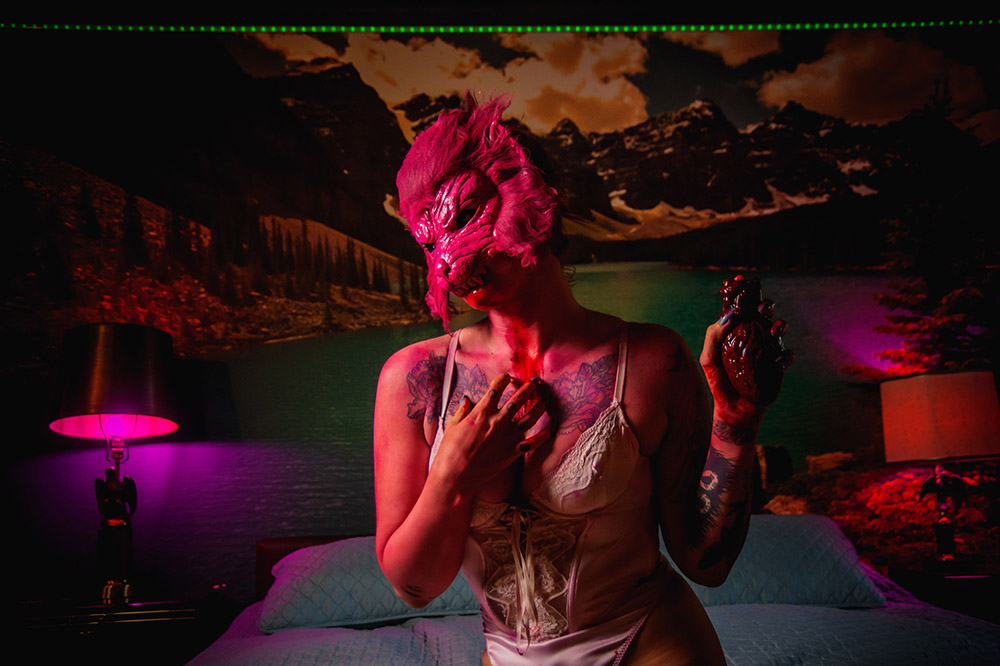 girl in a pink wolf mask wearing pink lingerie holding a bloody heart
