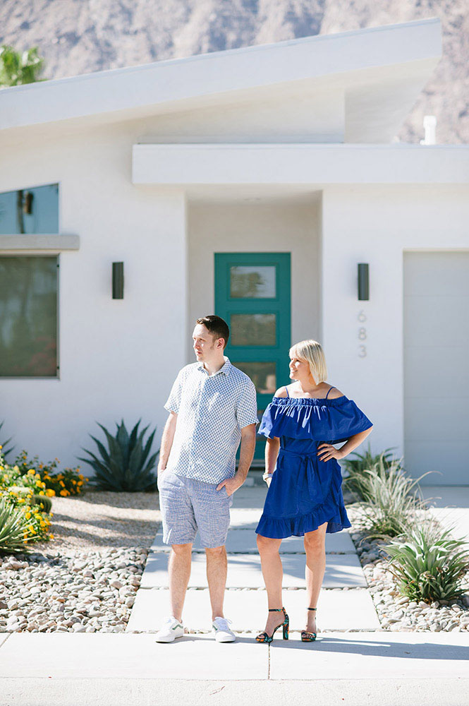 woman in blue dress with man in blue shorts in front of Palm Springs house