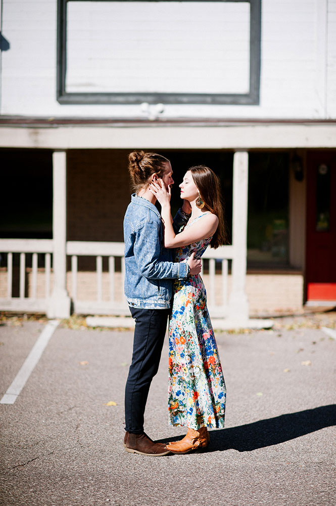 hipster guy in jean jacket girl with long floral dress in Western setting