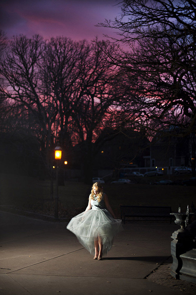girl in pale blue tulle dress at night with pink and purple sunset