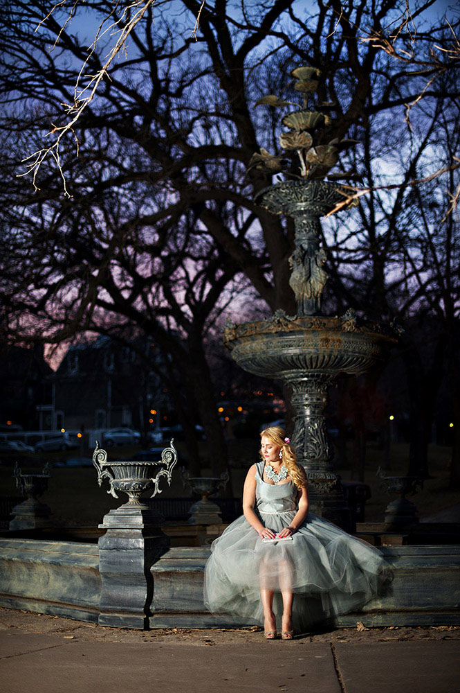 girl in pale blue tulle dress with blue flower necklace at Irvine Park fountain with blue and purple sunset
