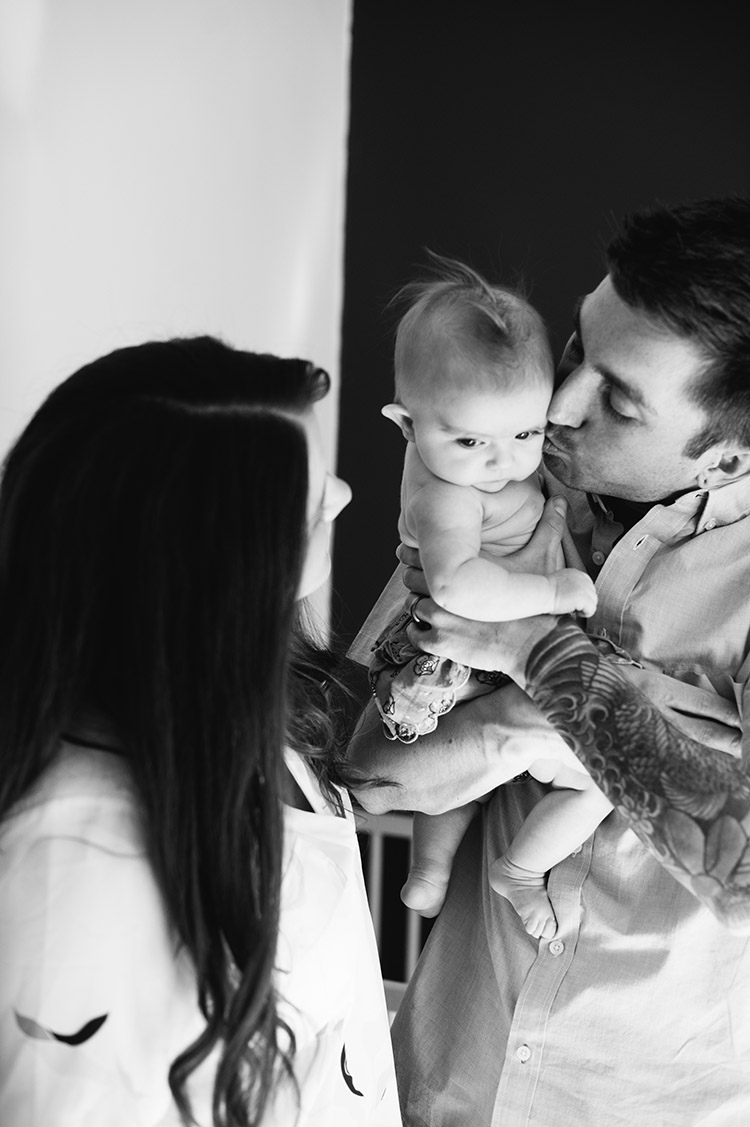 black and white photo of man kissing baby