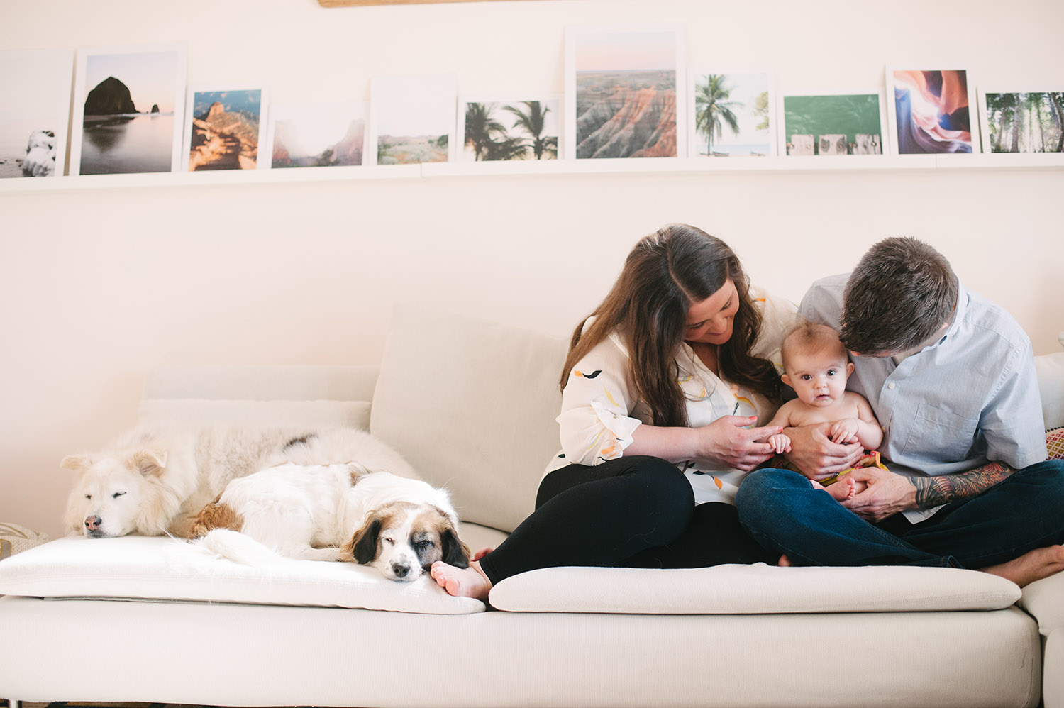 a couple and their baby on the couch with dogs