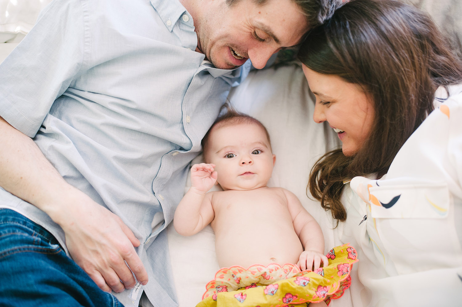 a couple on their bed with thier baby