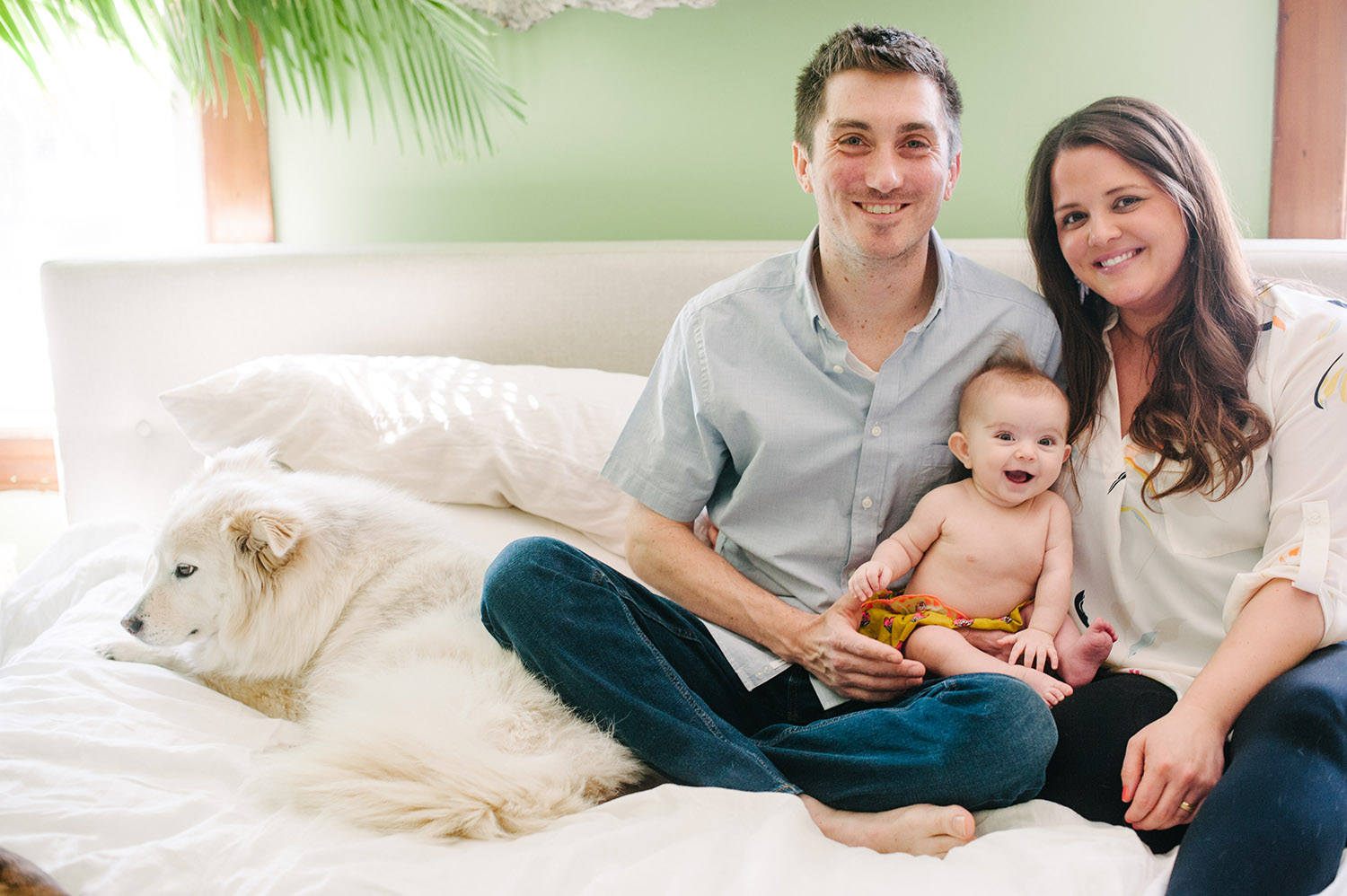 a couple on their bed with baby