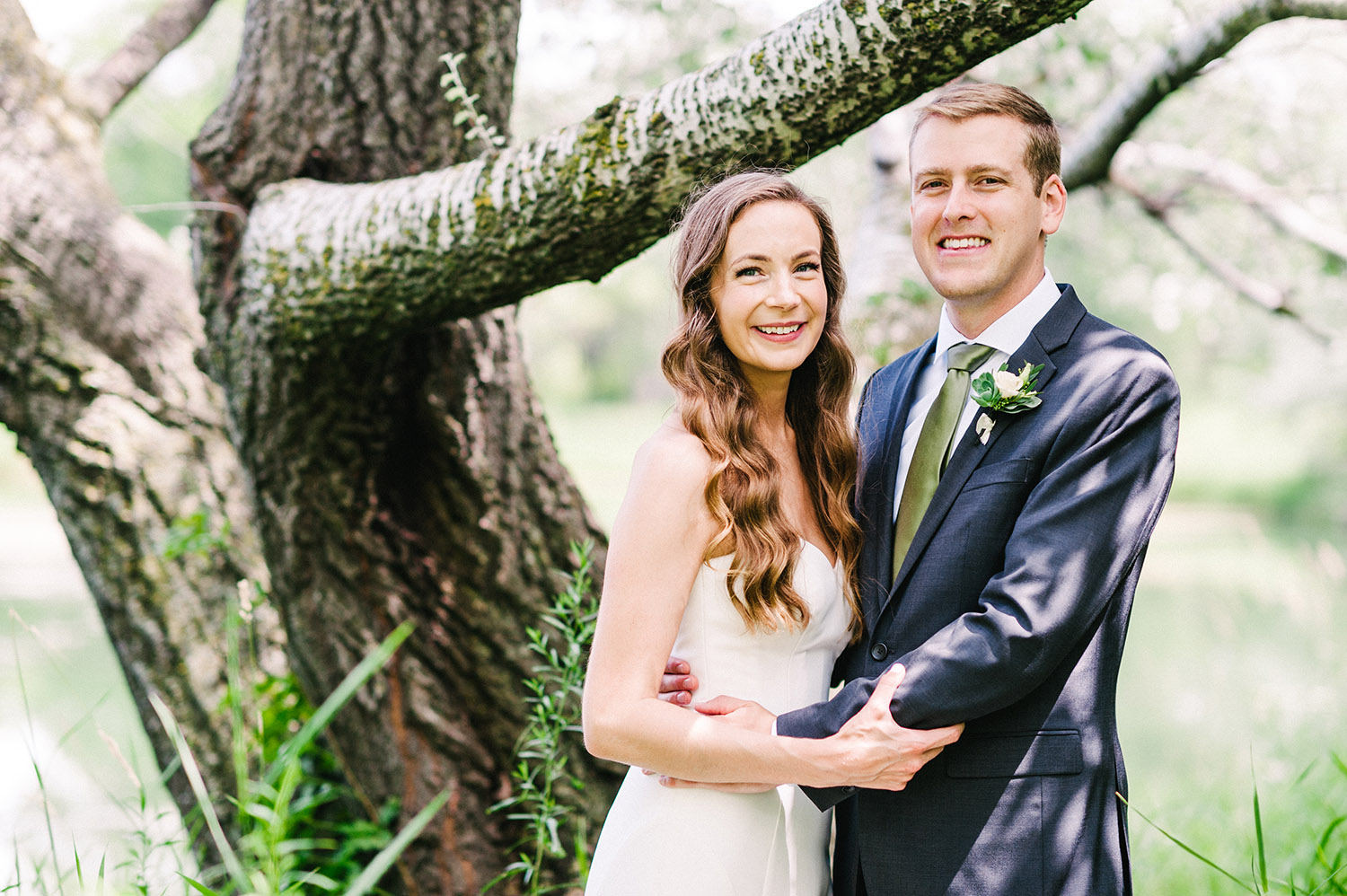 bride and groom in tall grasses with tree