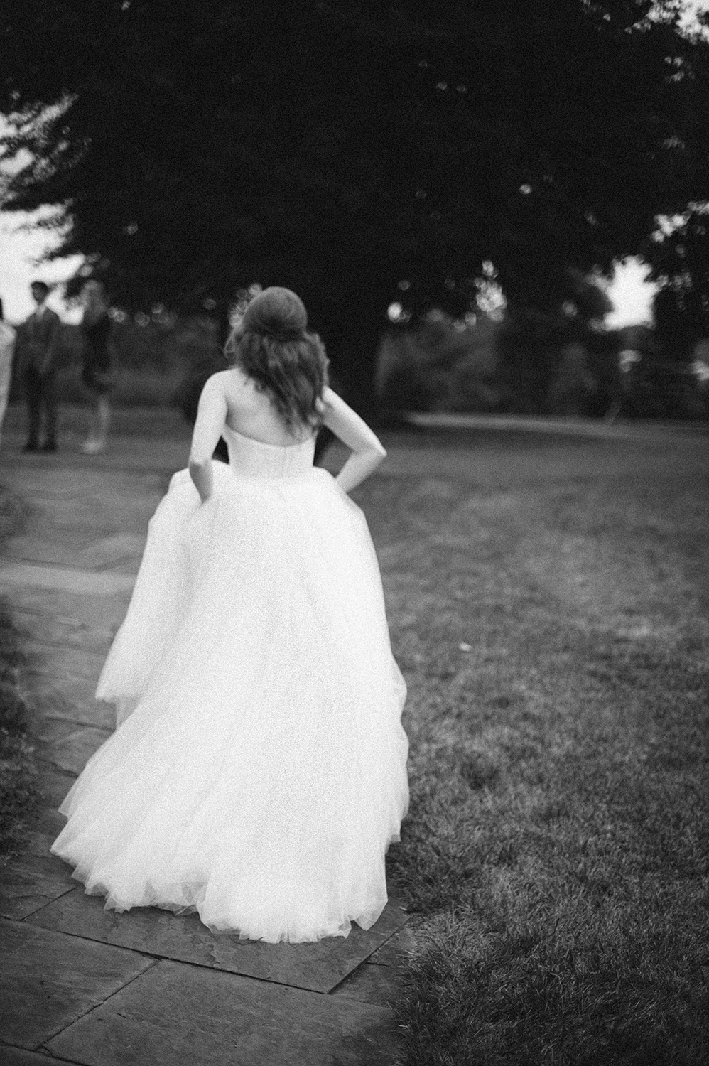 Bride in tulle dress running in black and white