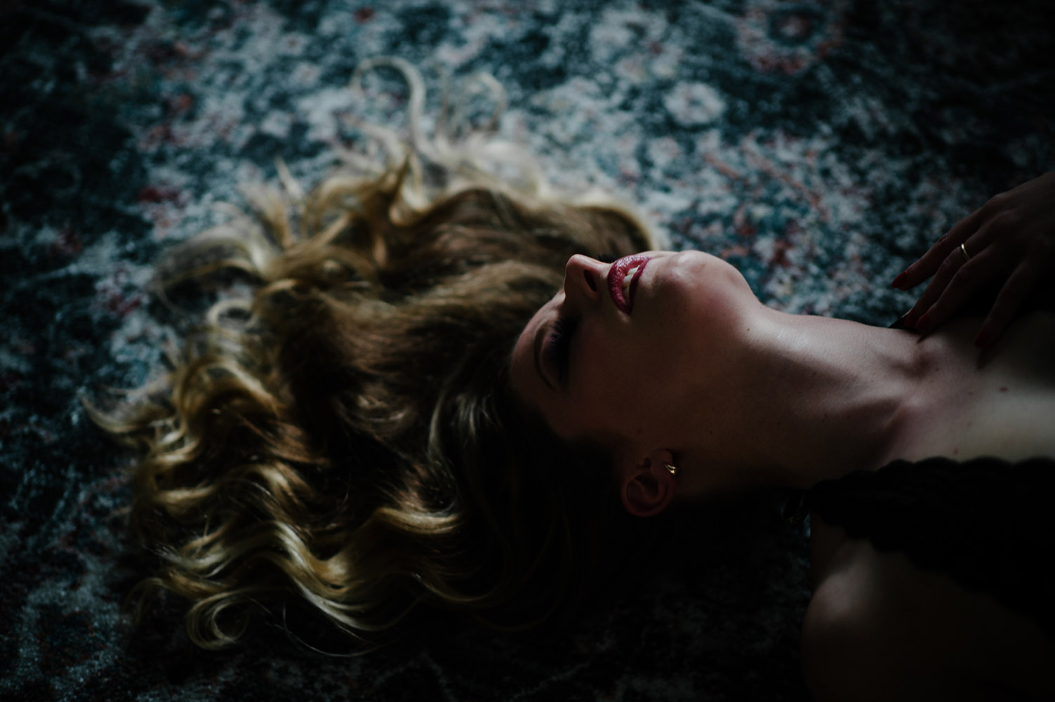 boudoir woman with blond hair lying on floor