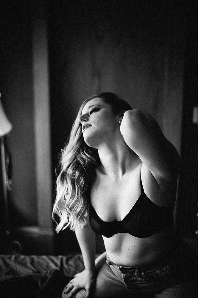 black and white boudoir woman in black bra on bed