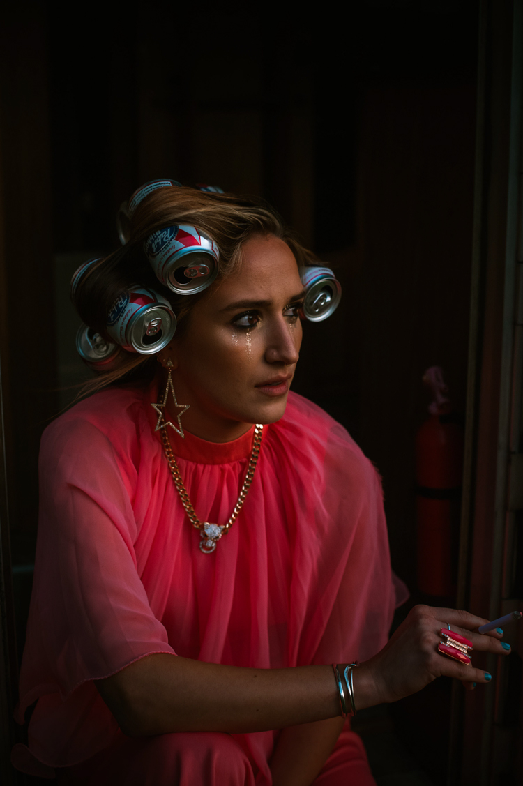 a white woman with beer cans in her hair and a pink dress