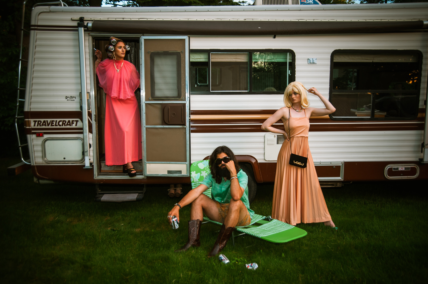 two white women and a white man hanging outside of an RV