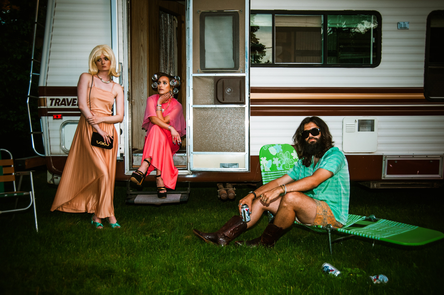 two white women and a white man hanging outside of an RV