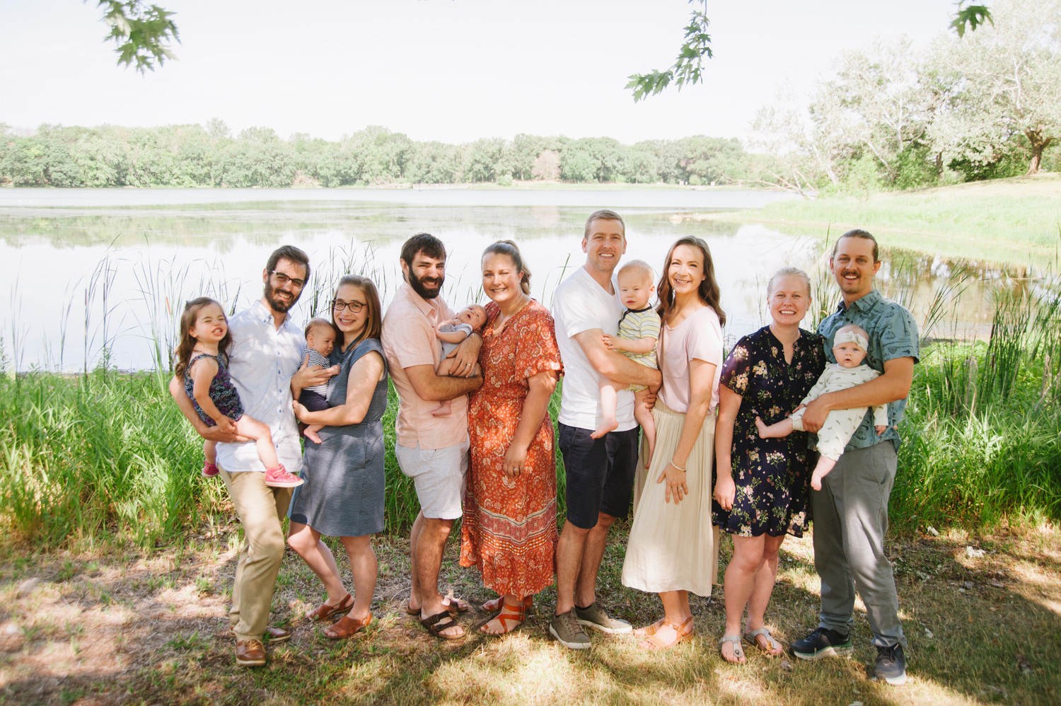 white couples and their babies by a lake