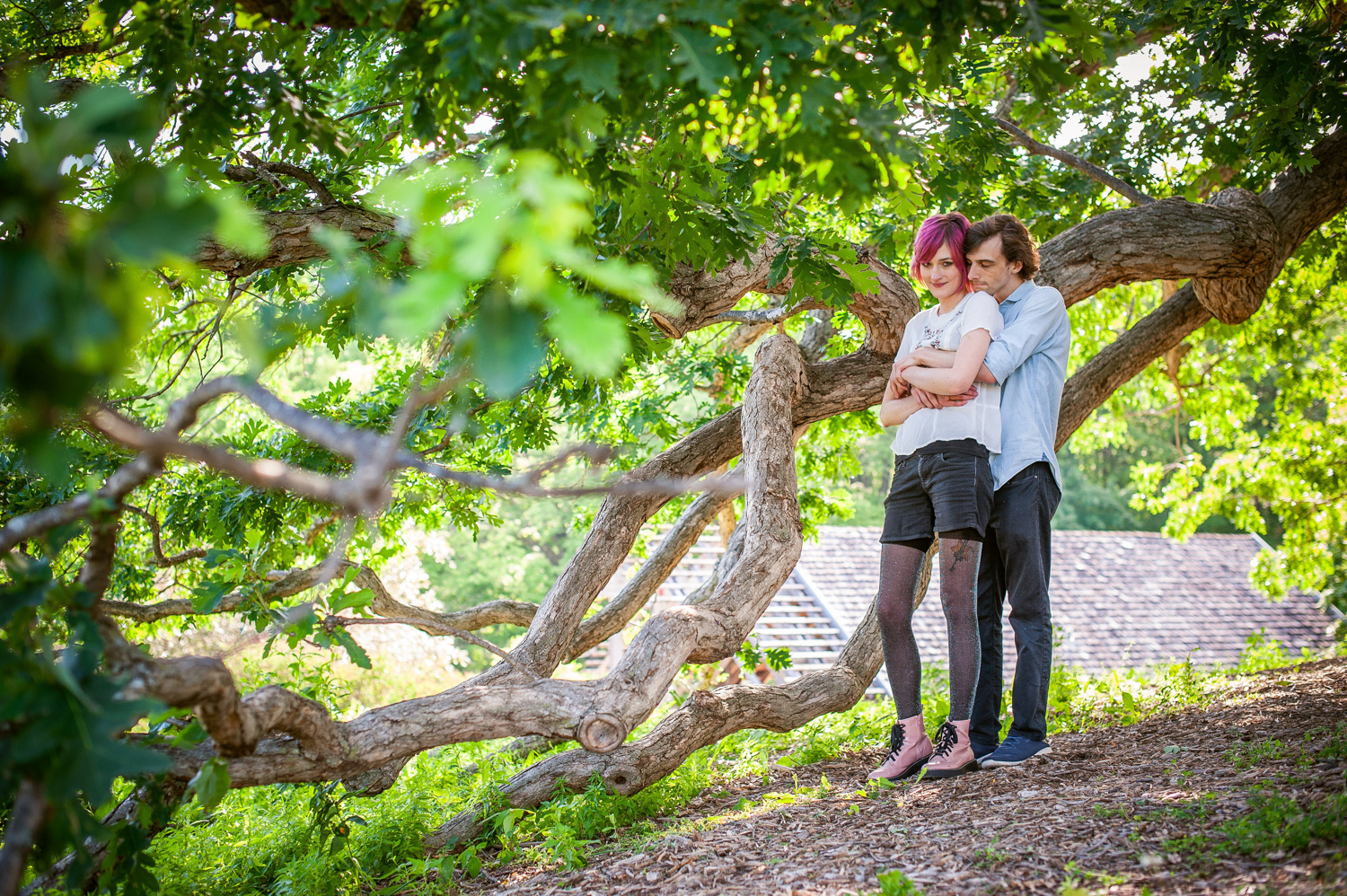 a young white couple standing under a tree at the Minnesota Landscape Arboretum