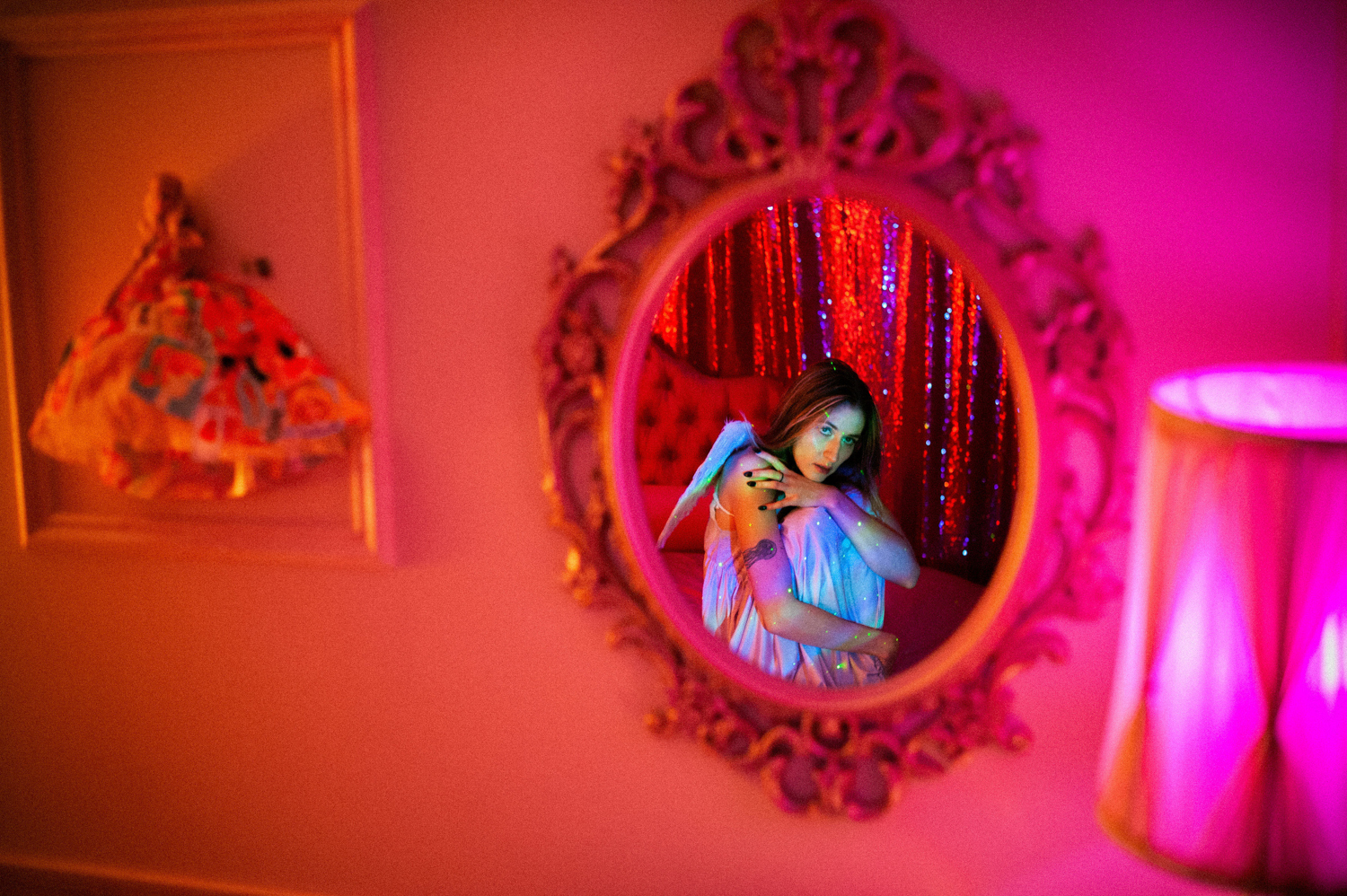 a reflection of a girl dressed like an angel in pink light at The Zebra House